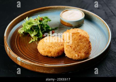 Gegrillte Lachsschnitzel mit Sauce auf schwarzem Hintergrund Stockfoto