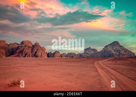 Planet Mars-ähnliche Landschaft - Foto der Wadi Rum Wüste in Jordanien mit rotem rosafarbenem Himmel oben wurde diese Location als Drehort für viele Science-Fiction-Filme genutzt Stockfoto