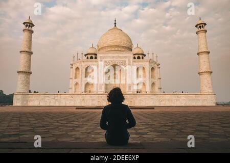 Junge Frau bewundern Taj Mahal Schönheit während Sonnenaufgang Zeit an einem bewölkten Tag, Agra, Indien Stockfoto