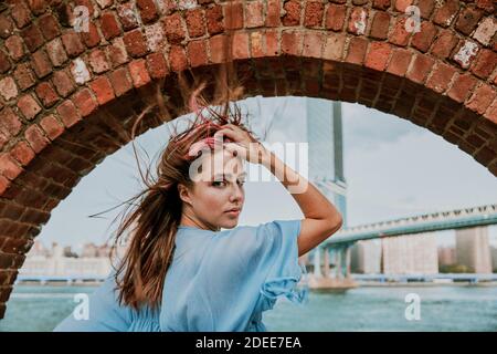 Porträt einer jungen Frau, die bei windigem Wetter steht. Stockfoto