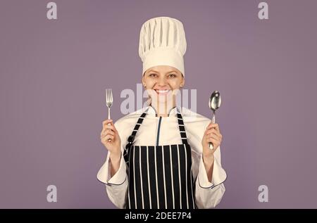 Portrait des Küchenchefs. Preisgekrönte Küche. Professionelle Chefköchin. Bereit zum Essen. Lässt kochen. Happy Cook verwenden Löffel und Gabel. Abendessen zubereiten zu Hause. Kochen ist mein Hobby. Stockfoto