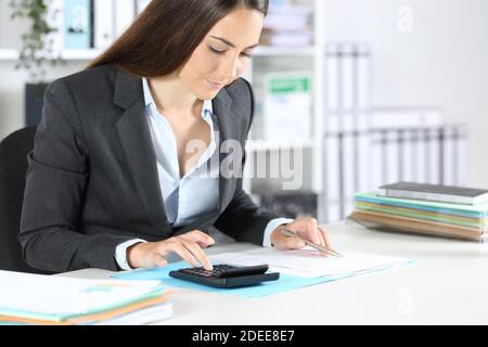 Buchhalterin Frau berechnet auf Rechner sitzen auf einem Schreibtisch bei Das Büro Stockfoto