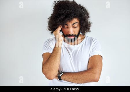 Der Mensch ist müde, Unzufriedenheit von anderen zu hören, bei der Arbeit. Unzufrieden männlichen Stand berühren Kopf, mit geschlossenen Augen Stockfoto