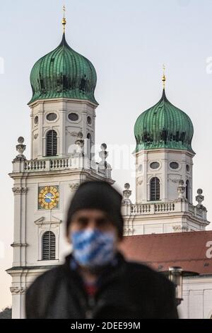 Passau, Deutschland. November 2020. Ein Mann geht mit einer Gesichtsmaske vor den Stephansdom. Nach Angaben des Robert Koch-Instituts (RKI) ist die niederbayerische Stadt Passau zusammen mit dem Thüringer Stadtteil Hildburghausen der Top-Corona-Hotspot in Deutschland. Quelle: Armin Weigel/dpa/Alamy Live News Stockfoto