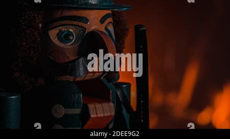 Hölzerne Nussknacker Figur Gesicht mit Feuer im Hintergrund brennen. Geringe Schärfentiefe. Nahaufnahme. Stockfoto