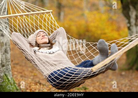 Ganzkörperportrait einer entspannten Frau, die auf Hängematte ruht Im Herbst Urlaub Stockfoto