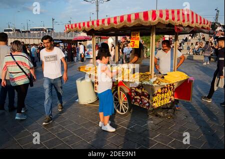 Istanbul, Türkei - September, 2018: Junge kaufen gegrillten Mais auf der Straße Stand von gerösteten Hühneraugen und Kastanien auf Eminonu-Platz. Traditionelle türkische Str. Stockfoto