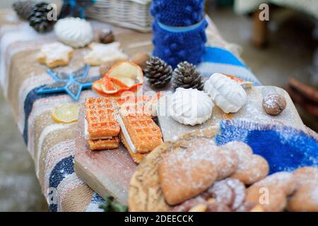 Einrichtung mit süßen Tischen in Winterblau. Süßigkeiten, Kekse und Marshmallows. Stockfoto