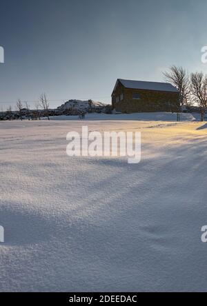 Februar und ein starker Schneefall bedeckt das Land und das Nebengebäude Rund um den Yorkshire Dales Kleinbetrieb Stockfoto