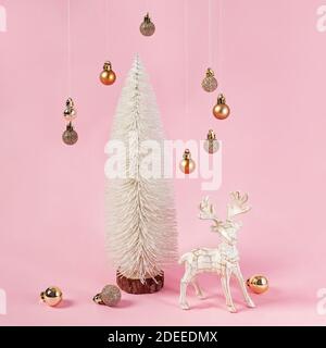 Weihnachtliche minimalistische Komposition mit weißem Baum, Rentieren und hängenden Kugeln Stockfoto