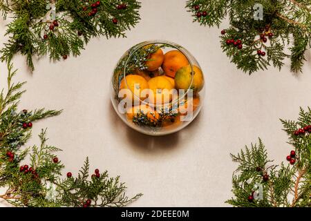 Süße Mandarinen aus Glas mit Kiefernzweigen und Kiefern verziert Kegel Stockfoto