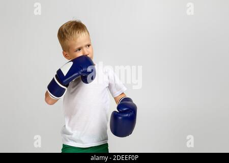 Kleiner Boxkämpfer Junge in blauen Boxerhandschuhen Kind träumt davon, ein Boxchampion. Copy space Stockfoto