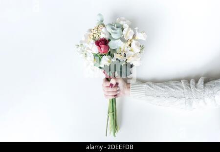 Zartes Bouquet von künstlichen Blumen aus Foamiran in weiblichen Händen. Grußkarte und Einladung zum valentinstag, Hochzeit, Jubiläum mit Kopie Stockfoto