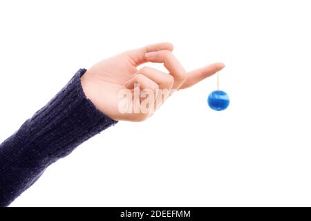 Weibliche Hand hält eine Weihnachtskugel Ornament isoliert auf einem weißen Hintergrund. Blaue runde Weihnachtsschmuck in der Hand einer Frau. Weihnachten und Neujahr Stockfoto