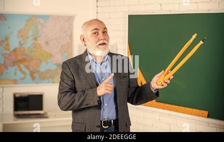 Älterer Mann Lehrer verwenden Kompass Werkzeug. Bärtiger Lehrer Mann zeichnen mit Kompass auf Tafel. Zurück zur Schule. Mathematische Grafik-Tools Konzept. Auf dem Weg zum Wissen. Studieren Sie Mathematik, um gute Ergebnisse zu erzielen. Stockfoto