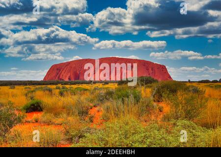Uluṟu oder Ayers Rock, Uluṟu - Kata Tjuṯa National Park, Northern Territory, Australien, 15. Januar 2012: Mit holländischen Wolken gegen den Himmel aufgenommen Stockfoto