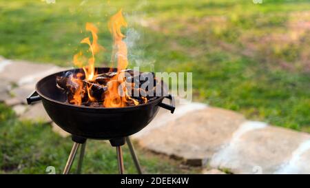 Das Verbrennen von Holz im Grill, Vorbereitung heißen Kohlen für Grillen von Fleisch in den Hinterhof. Flache Tiefenschärfe Stockfoto