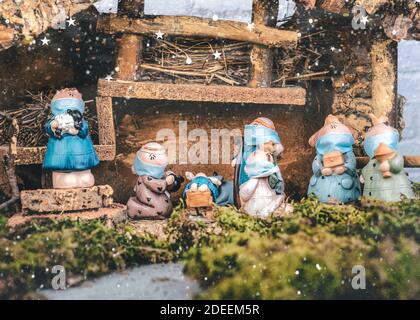 Weihnachtskrippe. Krippe Statuen Figuren mit schützenden chirurgischen Masken.Szene des geborenen Kindes Baby Jesus.Weihnachtskonzept Hintergrund Stockfoto