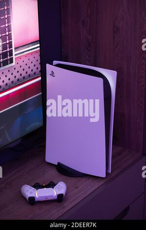 Moskau - November 28 2020: Die brandneue Sony PlayStation 5 Spielkonsole mit DualSense-Controller in der Nähe des fernsehbildschirms zu Hause einsatzbereit. Stockfoto