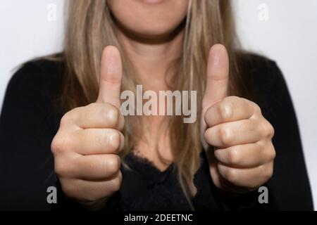 Unreconigzable Frau zeigt Daumen nach oben.glücklich, positiv, Erfolg Geste Konzept. Stockfoto