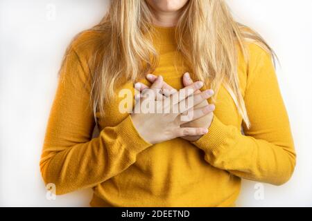 Junge Frau Crossing ihre Hände auf Brust isoliert auf weißem background.Concept des Friedens, Dankbarkeit, Glück, Liebe und Freundschaft Lifestyle Mockup. Stockfoto