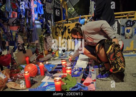 Ein junger Fan zündet vor den Toren des Stadions in den Tagen nach dem Tod des berühmten Fußballspielers eine Kerze an. Stockfoto