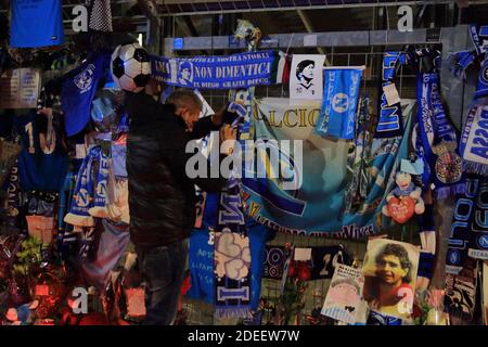 Ein Fan legt einen Schal von Neapel in Erinnerung an Diego Armando Maradona vor die Tore des San Paolo Stadium , in den Tagen nach dem Tod Stockfoto