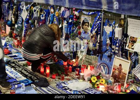 Eine Frau Fan stellt eine Kerze in Erinnerung an Maradona vor den Toren des San Paolo Stadium , in den Tagen nach dem Tod des berühmten Fußballers. Stockfoto