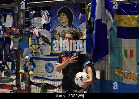 Ein junger Napoli-Fan posiert für das Souvenir-Foto mit shirt und Ball vor den Toren der San Paolo Stadion voller Objekte von Napoli-Fan links Stockfoto