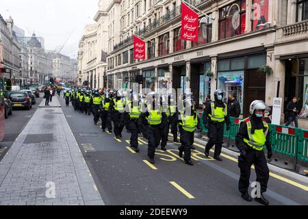 Anti-Lockdown Protest, London, 28. November 2020. Polizeibeamte in Bereitschaftstragewerk marschieren die Regent Street hinunter. Stockfoto