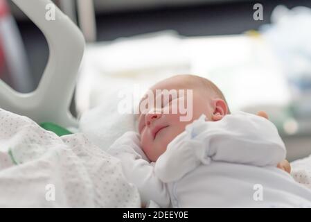 Neugeborenes Kind schläft in der Decke im Geburtsraum Stockfoto