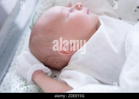 Neugeborenes Kind schläft in der Decke im Geburtsraum Stockfoto