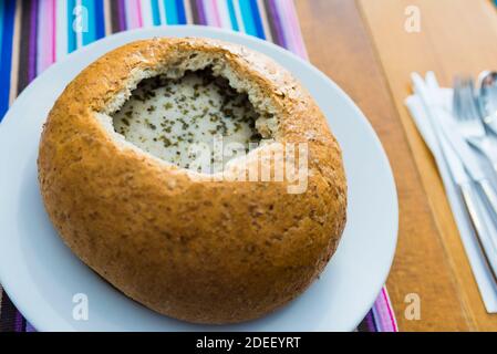 Traditionelle polnische Küche: Zuek tresciwy w chlebie - z jajem ekologicznym. Traditionelle fleischige Suppe in Brot mit Hühnereier serviert. Altstadt. Warschau, Pol Stockfoto