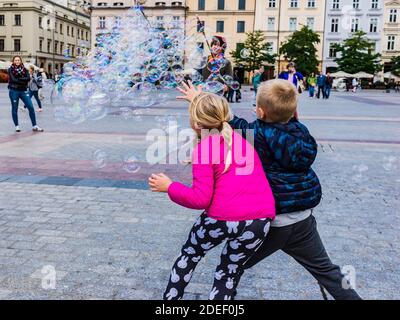 Kinder spielen mit Seifenblasen auf dem Hauptmarkt, Krakau, Kreis Kraków, Woiwodschaft Kleinpolen, Polen, Europa Stockfoto