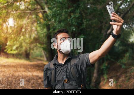 Der Junge macht mit seinem Handy ein Selfie in den Bergen. Wanderroute in den Bergen. Konzept der Gesundheit. Berg Stockfoto