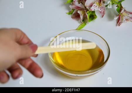 Bild von flüssigem Zucker für Haare Enthaarung Wachs Glas aus goldenem Honig Closep mit Frangipani Blumen. Vorbereitung natürliche Schönheit Körper behandeln Stockfoto