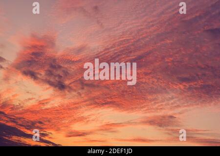 Feuerhimmel Hintergrund. Weiche Wolken mit dem Hauch der Sonne bei Sonnenuntergang. Viele Orange Töne und Muster von Wolken. Stockfoto