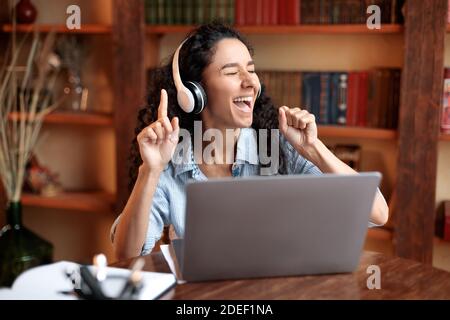 Frau, die online Musik über Kopfhörer hört Stockfoto