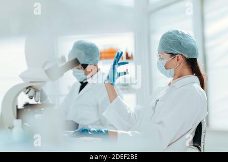 Ampulle mit einem Impfstoff in den Händen einer Wissenschaftlerin. Stockfoto