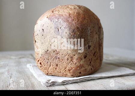 Hausgemachtes Vollkorn Roggen Weizen Sauerteig Bio Brot Laib auf Leinen Serviette auf Holz Hintergrund Stockfoto