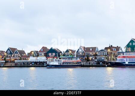 VOLENDAM, NIEDERLANDE - 24. Dezember 2019: Holländischer Hafen mit Blick auf die Stadt, Boote, Weihnachtsschmuck. Winterabend in der traditionellen Altstadt, holländisch Stockfoto