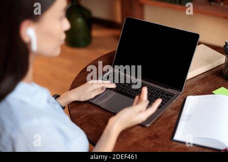 Frau mit Laptop mit leerem Mockup-Bildschirm, reden Stockfoto