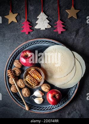 Metallplatte mit Apfel, Walnüssen, weihnachts-Waffeln, Knoblauchzwiebeln und Glas Honig. Weihnachtsdekoration. Overhead-Ansicht. Stockfoto