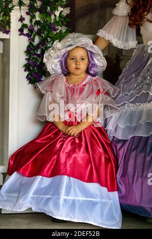 Schönes kleines Mädchen in einem luxuriösen vintage roten Kleid gekleidet.Puppet Museum, Juli 2020 in Preili, Lettland. Stockfoto