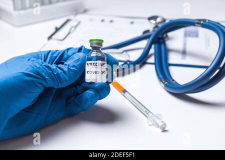 Arzt, Wissenschaftler oder Krankenschwester Hand in blauen Handschuhen hält Ampulle Coronavirus Impfstoff Schuss für Krankheiten Ausbruchsimpfung, Medizin und Drogenkonzept Stockfoto