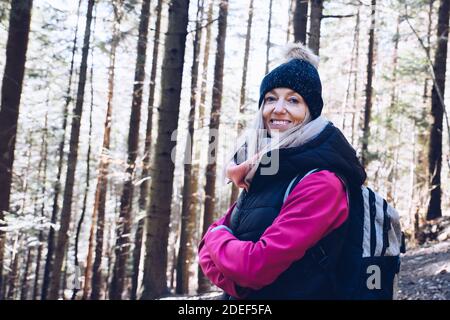 Lächelnde Frau wandern im Herbstwald auf Trail. Stockfoto