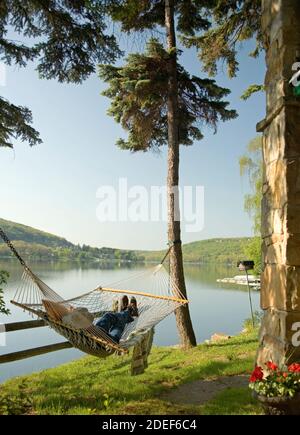 Lake House mit Eigentümer in Hängematte Stockfoto