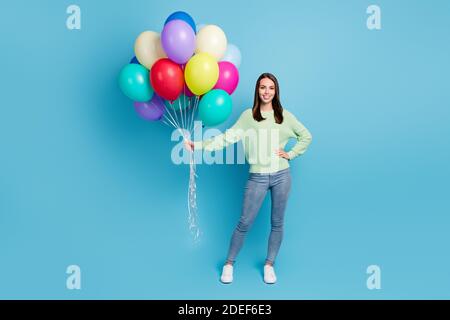 In voller Länge Körpergröße Foto von schönen freundlichen Mädchen feiern Urlaub mit Luftballons lächelnd isoliert auf hellblauen Hintergrund Stockfoto