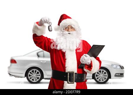 Santa Claus mit einem neuen silbernen Auto zeigt Autoschlüssel Und halten Sie eine Zwischenablage isoliert auf weißem Hintergrund Stockfoto