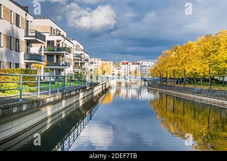 Berlin, Deutschland - 24. Oktober 2020: Hafenbecken Tegeler Hafen mit alten und modernen Gebäuden, Wohneinheiten, Fußgängerbrücke und herbstfarbenem Baum Stockfoto